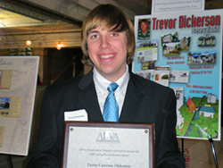 Trevor Dickerson with his APVA Young Preservationist of the Year Award standing in front of a collage depicting some of his preservation accomplishments and interests.